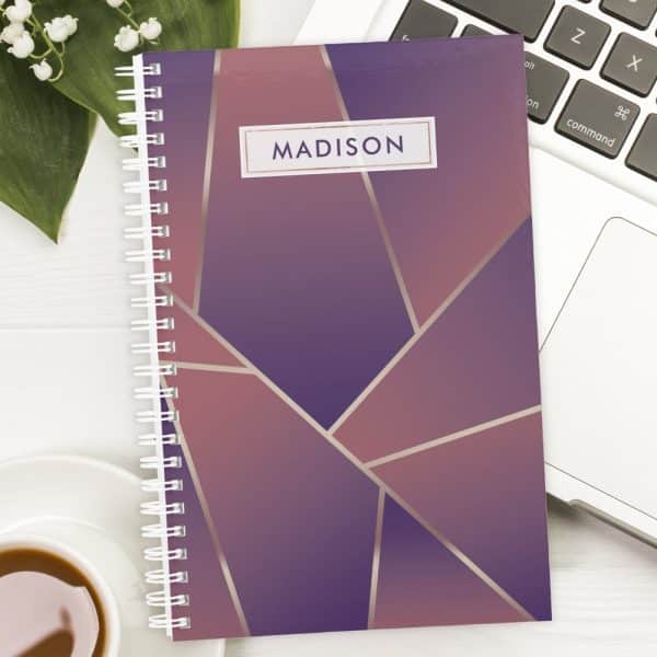 Spiral-Bound Notebook With A Purple And Rose Gold Geometric Design And The Name Madison On The Cover.