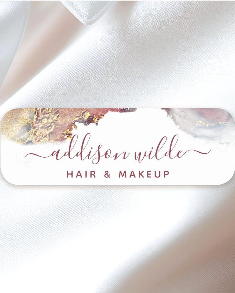 Addison Wilde Hair & Makeup logo with gold and maroon watercolor design.