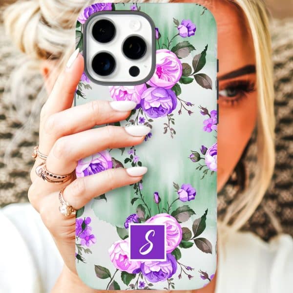 A Woman'S Hand Holds Up A Phone Case Featuring A Floral Design Of Purple And Pink Roses On A Sage Green Background. A Purple Monogram Is In The Lower Center.