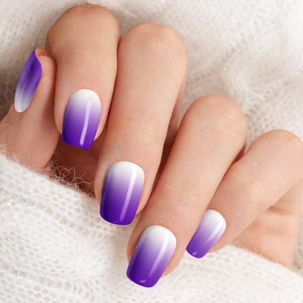 Close-Up Of A Hand With Ombre Purple And White Nails.
