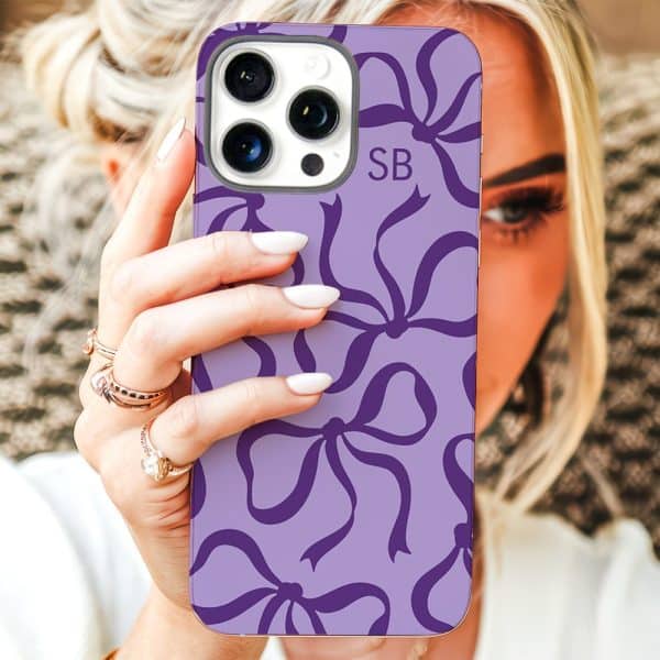A Woman Holds Up A Lavender Phone Case With A Purple Bow Pattern And Initials Sb.