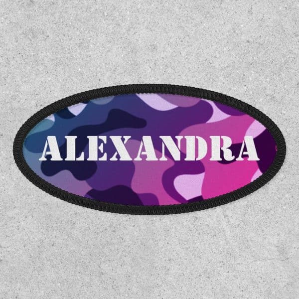 Oval Purple And Pink Camouflage Patch With The Name Alexandra In White Lettering.