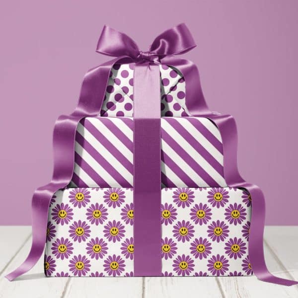 A Stack Of Three Presents Wrapped In Purple And White Patterned Paper, Tied With A Large Purple Ribbon.