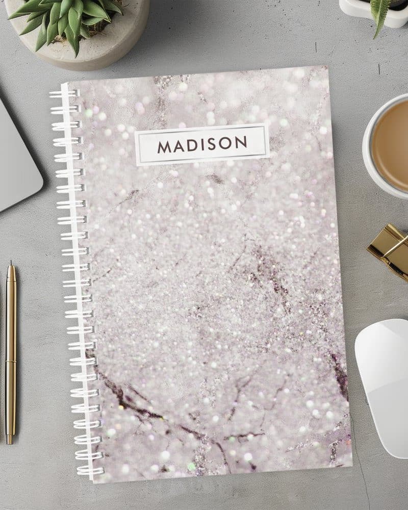 Spiral-bound notebook with a sparkly marble cover and the name Madison on the front.