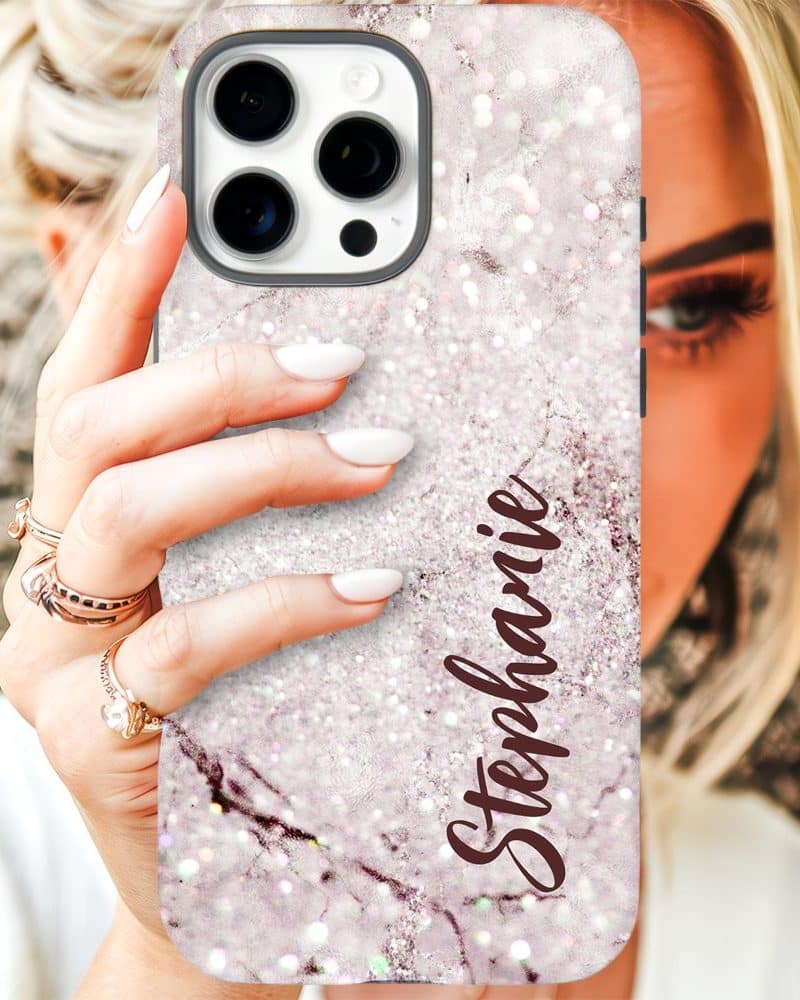 A hand holds up a white glitter iPhone case with the name Stephanie on it.