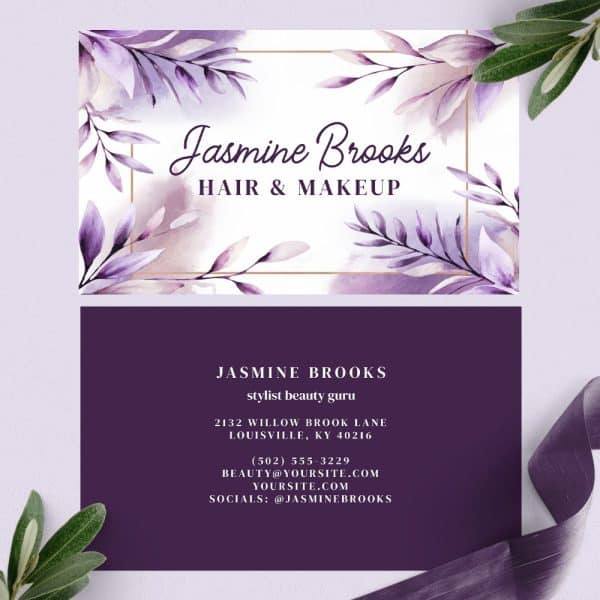 A Business Card For Jasmine Brooks, Hair And Makeup Stylist, Featuring A Watercolor Design Of Purple Leaves And A Gold Frame.