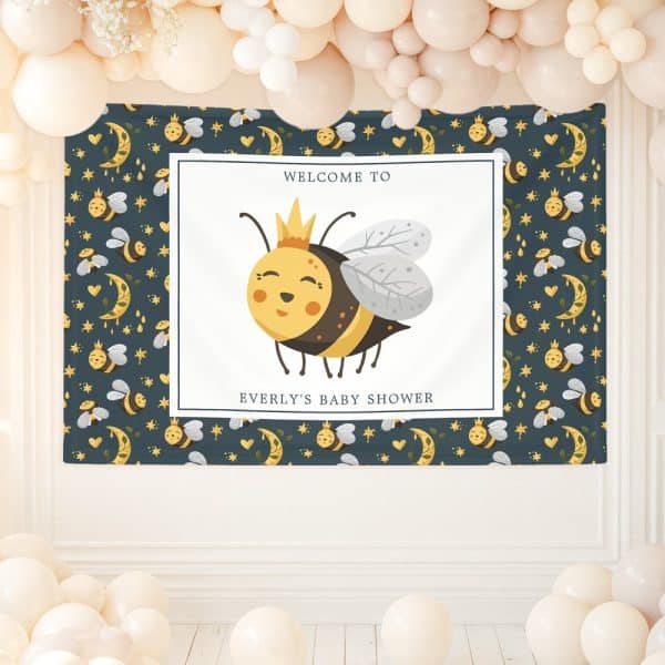 A Baby Shower Banner Featuring A Cartoon Bee Wearing A Crown. The Banner Has A Dark Blue Background With A Repeating Pattern Of Bees, Moons, And Stars.