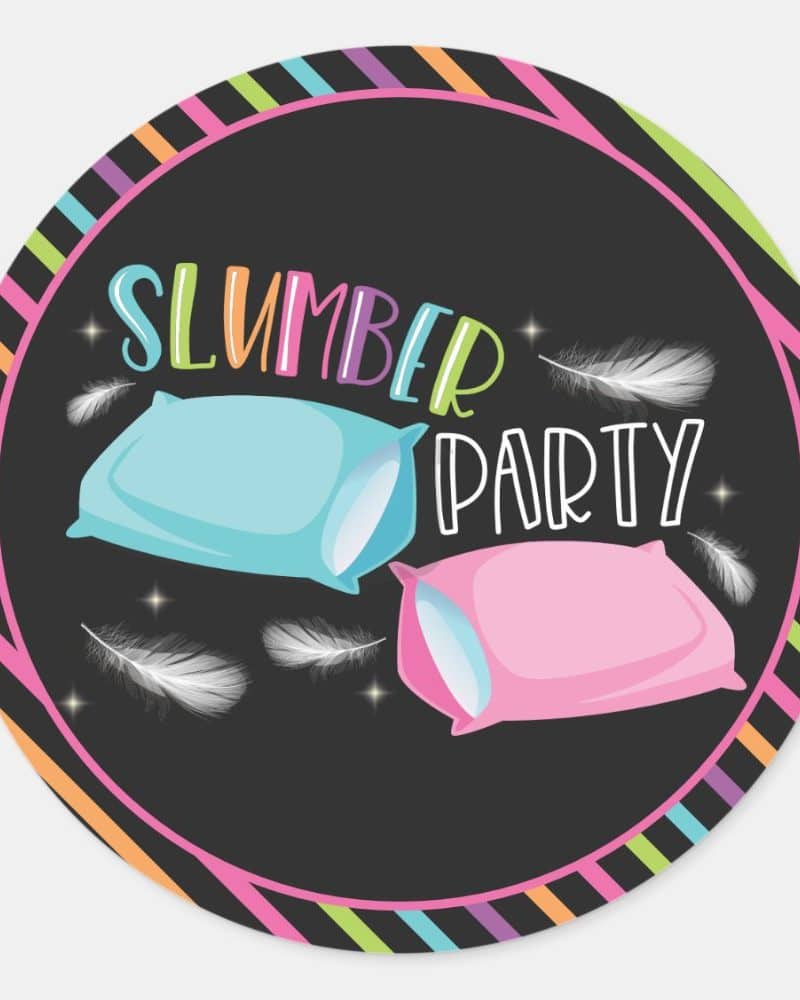 Slumber party invitation featuring two pillows and feathers on a dark background with a colorful striped border.