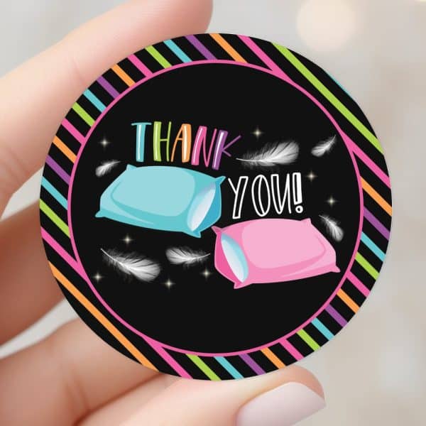 Round Thank You Sticker With A Black Background, Neon Stripes, Two Pillows, And White Feathers.
