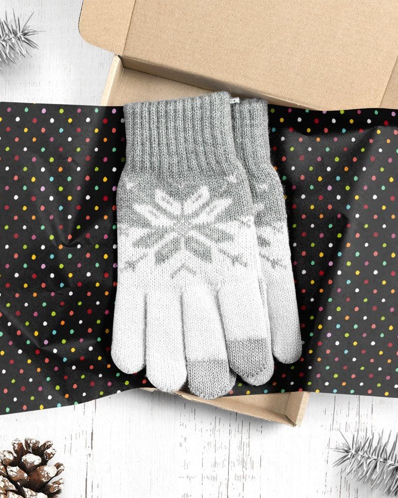 Pair of grey and white knit gloves with snowflake pattern in a gift box.