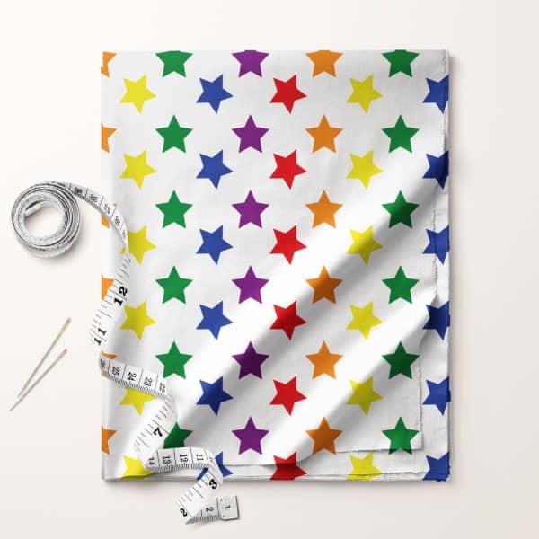 Rainbow Star Patterned Fabric With Measuring Tape And Pins.