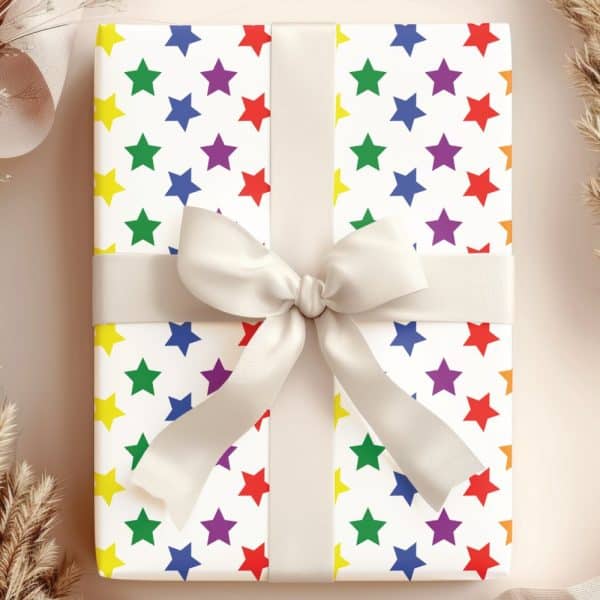 A Gift Wrapped In White Paper With A Rainbow Star Pattern And A Large Off-White Bow.