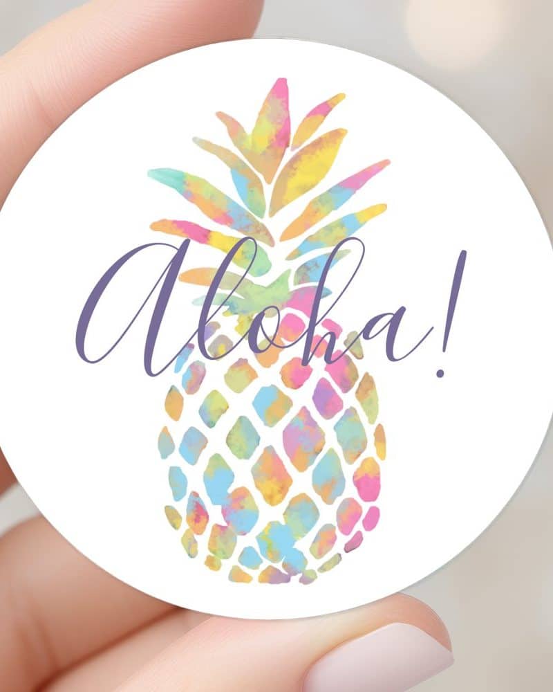 Round sticker featuring a pastel watercolor pineapple and the word Aloha.