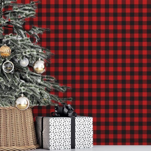 A Decorated Christmas Tree And A Gift Sit In Front Of A Red And Black Buffalo Plaid Background.
