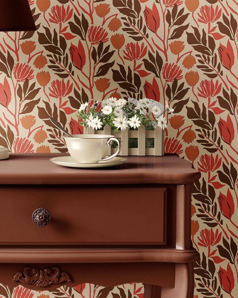 A teacup and saucer sit on a dark brown wooden bedside table, in front of a floral wallpaper.