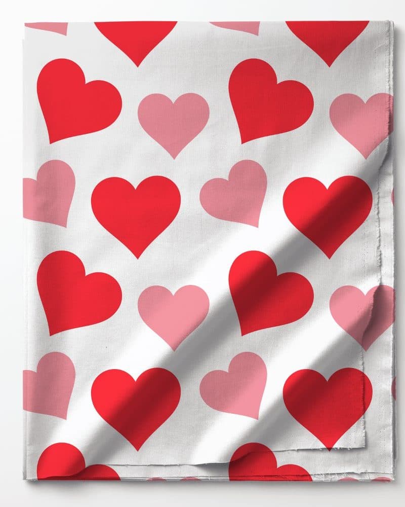 White fabric with a repeating pattern of red and pink hearts.