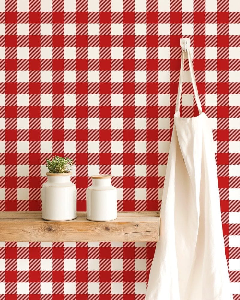 Red and white gingham wallpaper with a white apron hanging on a wooden shelf.