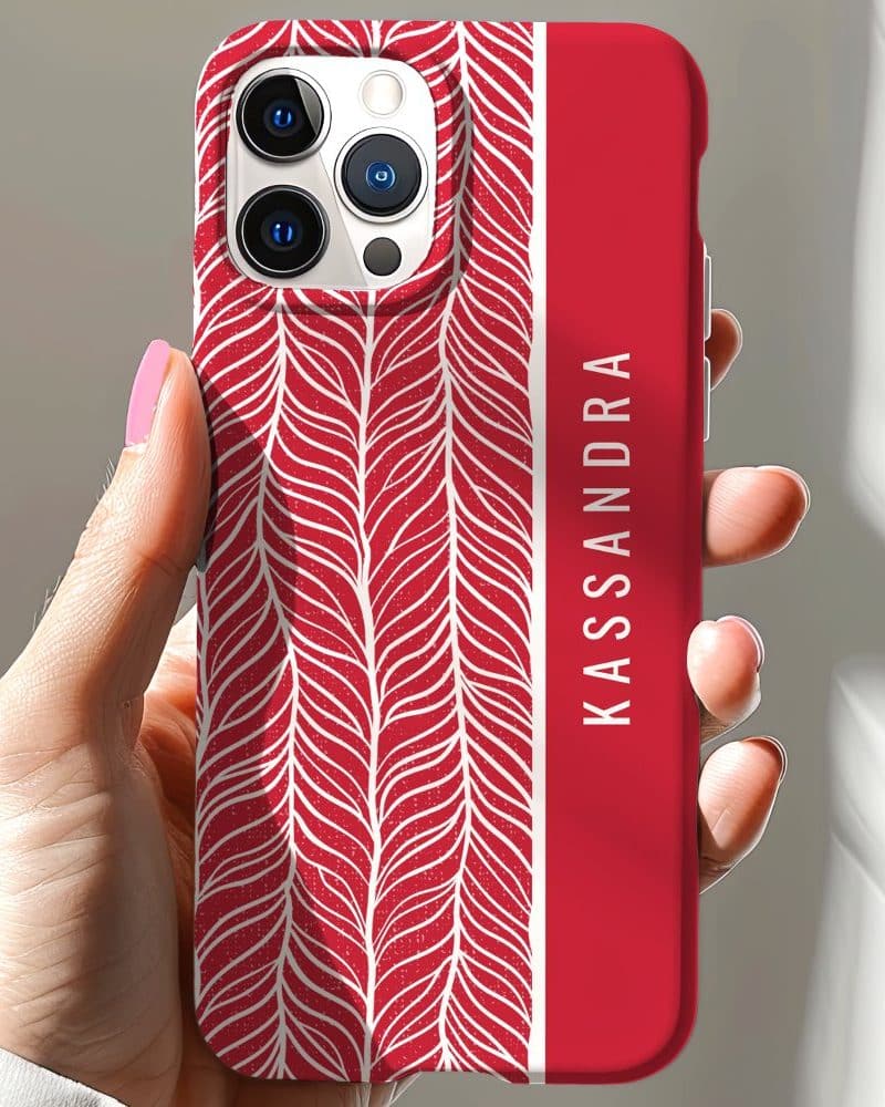 Red iPhone case with a white leaf pattern and the name Kassandra.