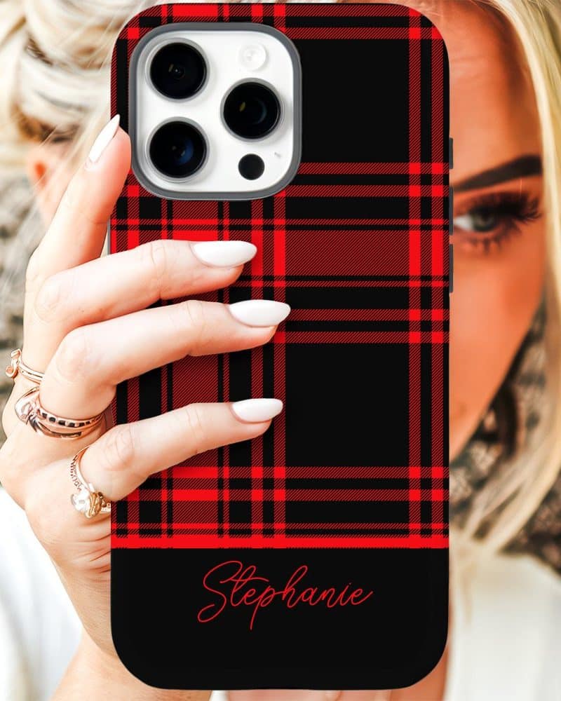 A woman's hand holds up a black phone case with a red plaid pattern and the name Stephanie on the bottom.