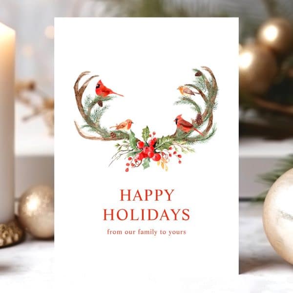 Happy Holidays Card Featuring Watercolor Artwork Of Birds And Greenery Adorning A Set Of Antlers.