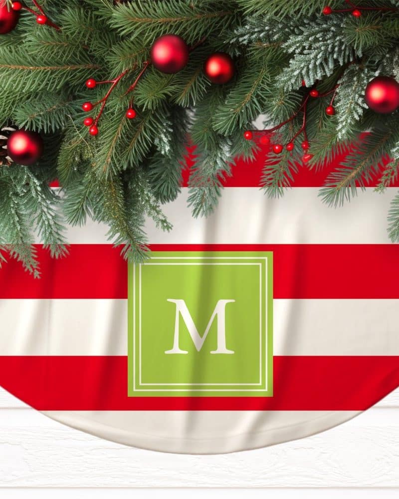 Red and white striped Christmas tree skirt with a green monogrammed M.
