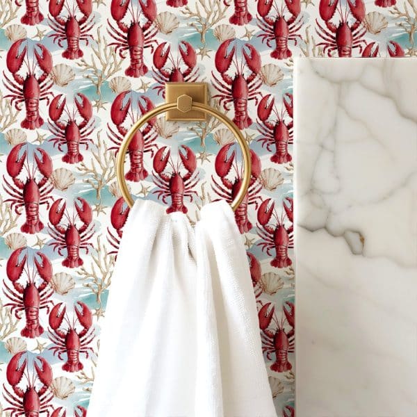 White Towel Hanging On A Gold Ring Against A Wallpaper Of Red Lobsters And Seashells.