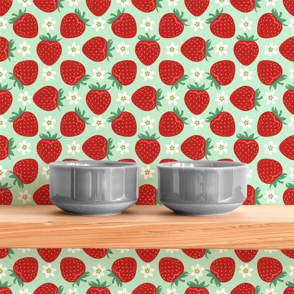 Two Gray Bowls Sit On A Wooden Shelf In Front Of A Strawberry Wallpaper.