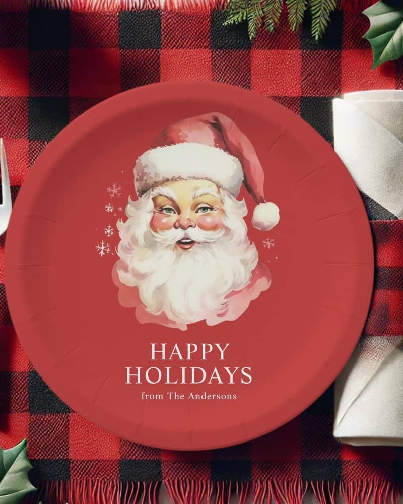 Red paper plate with a vintage illustration of Santa Claus's face and the text Happy Holidays from The Andersons.