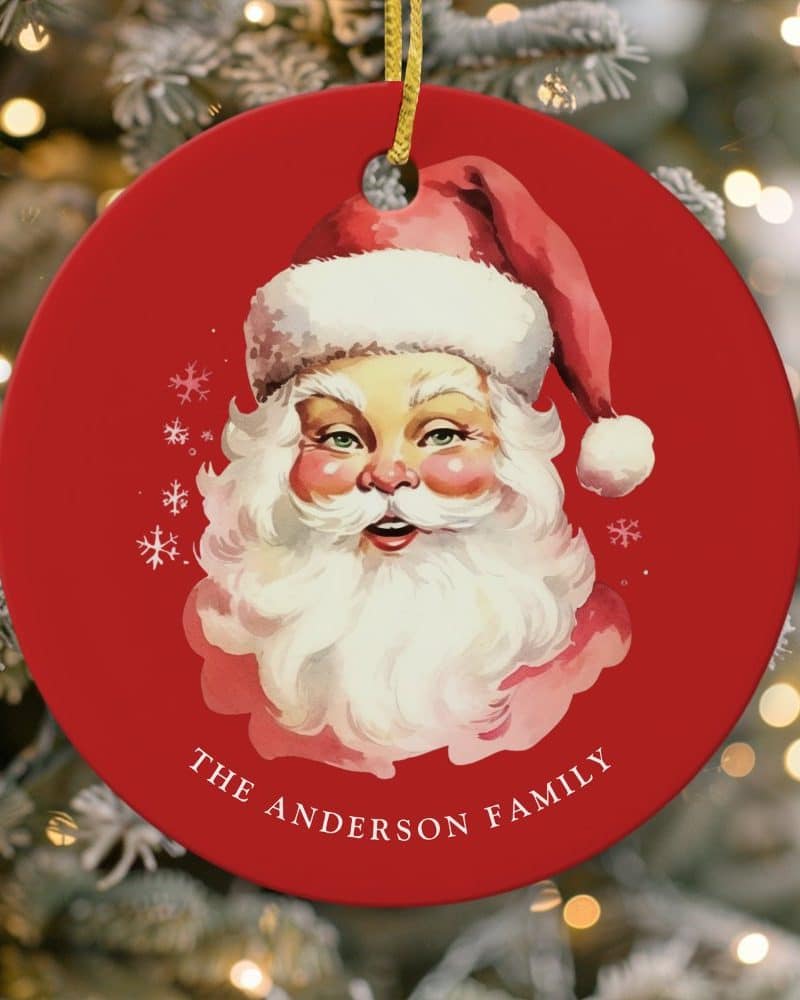 Red Christmas ornament featuring a vintage illustration of Santa Claus's face, with the text The Anderson Family below.