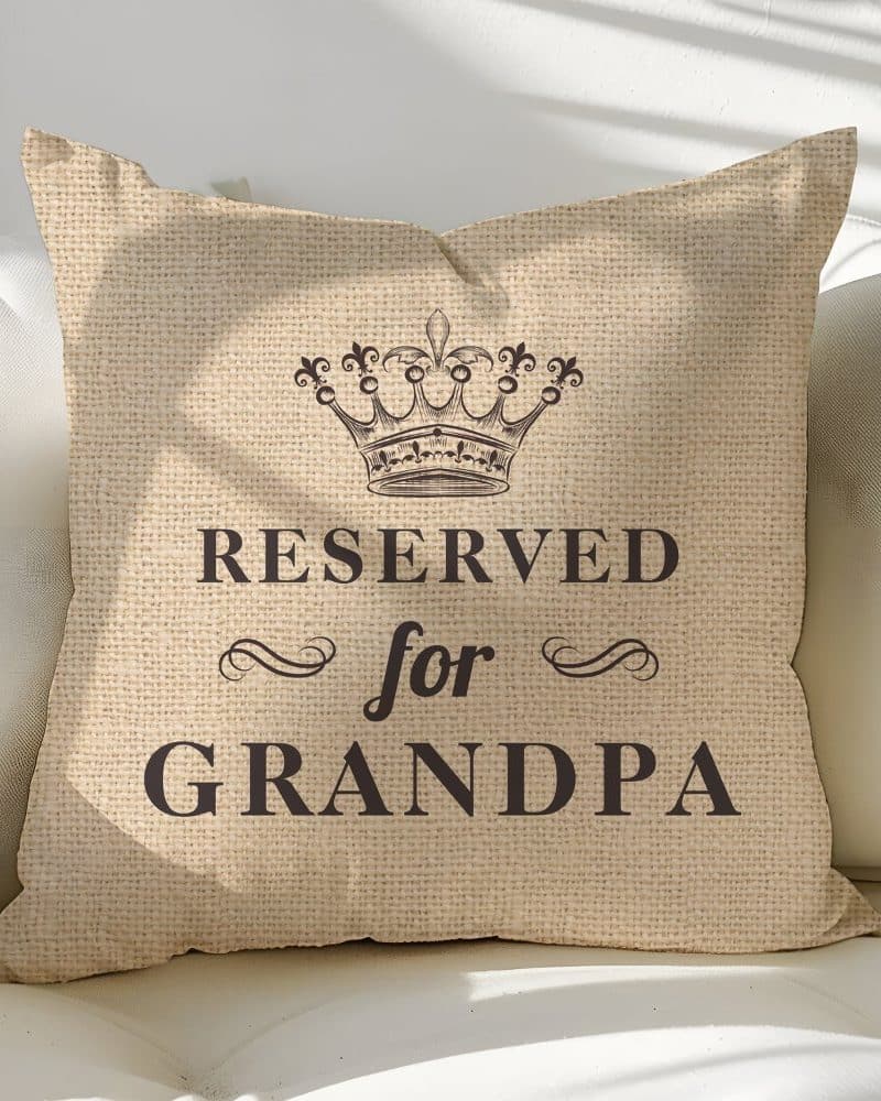 Beige throw pillow with a crown and the text Reserved for Grandpa.