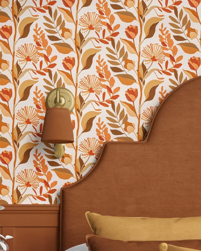 Orange and brown floral wallpaper on a bedroom wall, partially visible behind a brown headboard.