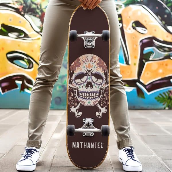 Person Holding Skateboard With Decorated Sugar Skull Graphic.