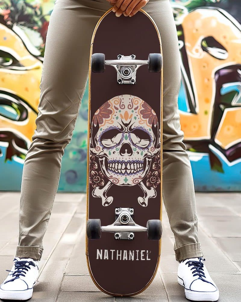 Person holding skateboard with decorated sugar skull graphic.