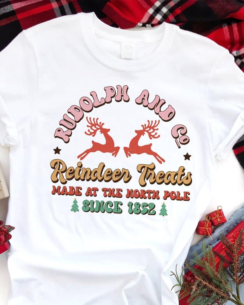 White t-shirt with a retro design featuring Rudolph and Co. Reindeer Treats, made at the North Pole since 1852.