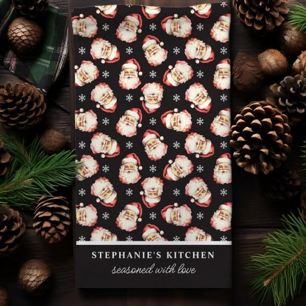 Christmas Kitchen Towel With A Repeating Pattern Of Santa Claus Faces, Personalized With The Name Stephanies Kitchen.