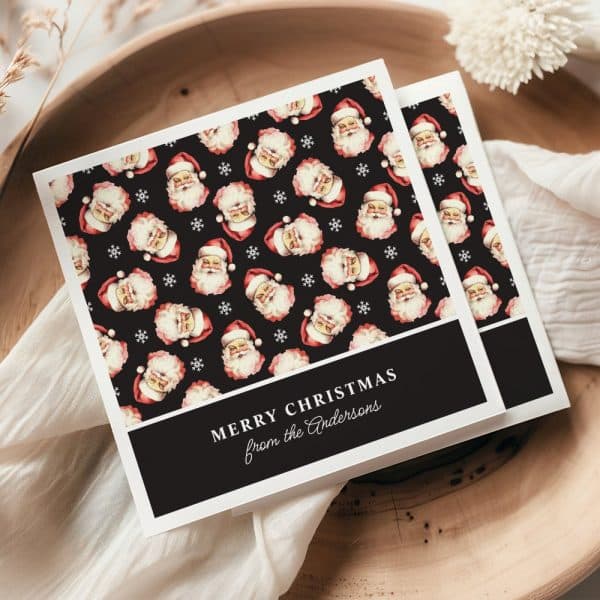 A Christmas Card With A Repeating Pattern Of Santa Claus Faces On A Black Background. The Card Reads Merry Christmas From The Andersons.