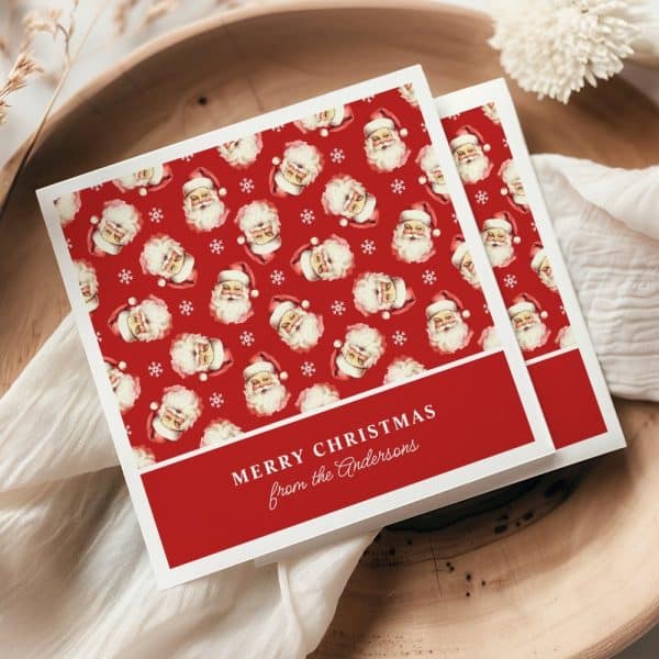 Christmas Card With A Red Background And Repeating Pattern Of Santa Claus Faces. The Card Reads Merry Christmas From The Andersons.
