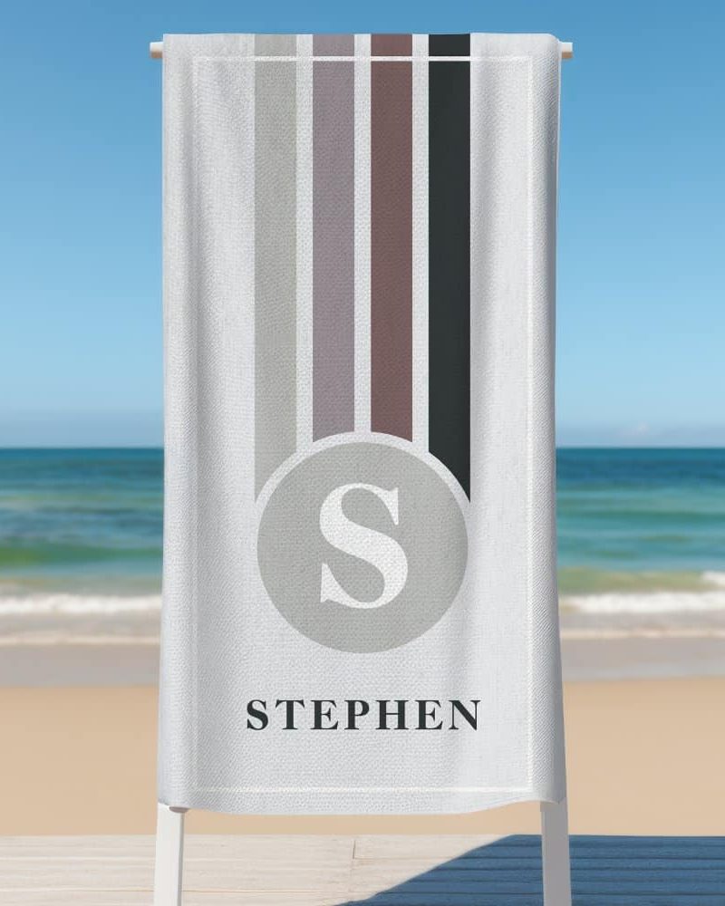 Personalized beach towel with vertical stripes and the letter S in a circle, along with the name Stephen.