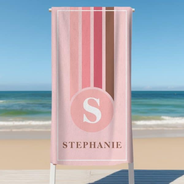 Pink Beach Towel With Vertical Stripes And The Letter S In A Circle, Personalized With The Name Stephanie.