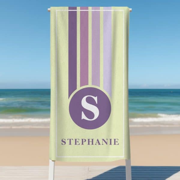 Personalized Beach Towel With Pastel Vertical Stripes, A Purple Circle Containing The Letter S, And The Name Stephanie Below.