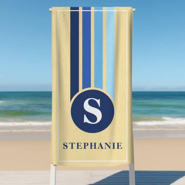 Beige Beach Towel With Blue And Light Blue Vertical Stripes, A Navy Blue Circle Containing The Letter S, And The Name Stephanie.