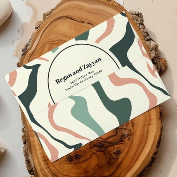 Envelope With Abstract Green, Pink, And Cream Design, Addressed To Regan And Zayyan.