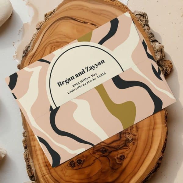 An Envelope With An Abstract Design In Pink, Cream, Black, And Gold, Addressed To Regan And Zayyan In Louisville, Kentucky.