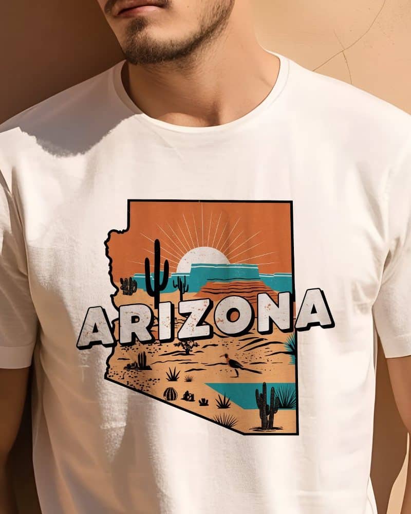 Man wearing a white t-shirt featuring an Arizona-shaped graphic with a desert landscape and rising sun.