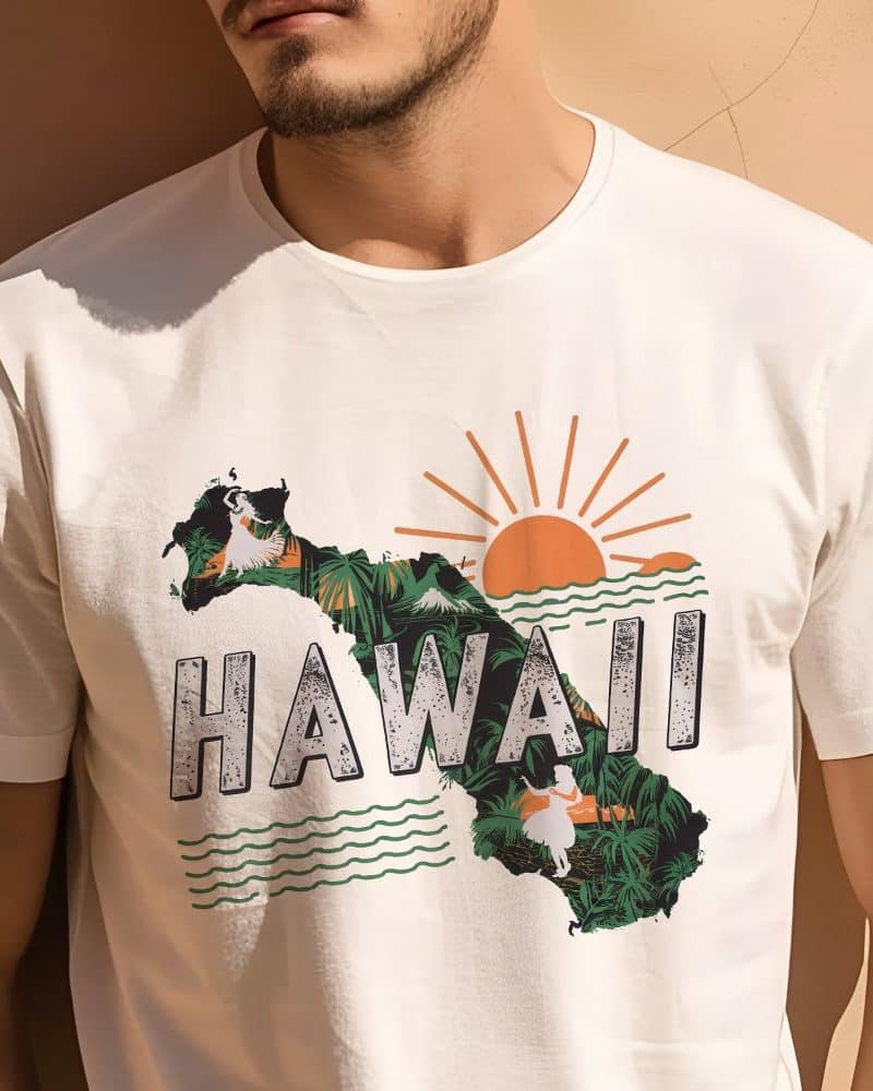 Man wearing a cream-colored t-shirt featuring a graphic design of Hawaii's outline, tropical imagery, and the word "Hawaii".