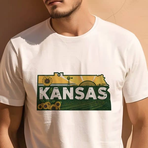 Man Wearing A White T-Shirt With A Kansas-Shaped Graphic Featuring Sunflowers, A Windmill, And A Sunrise.