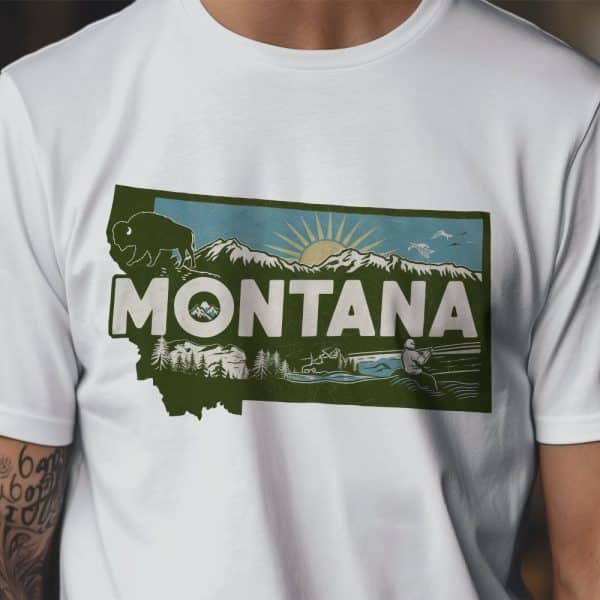 White T-Shirt With A Vintage-Style Graphic Of The State Of Montana. The Design Includes Mountains, A Bison, A Sun, And A Person Fishing.