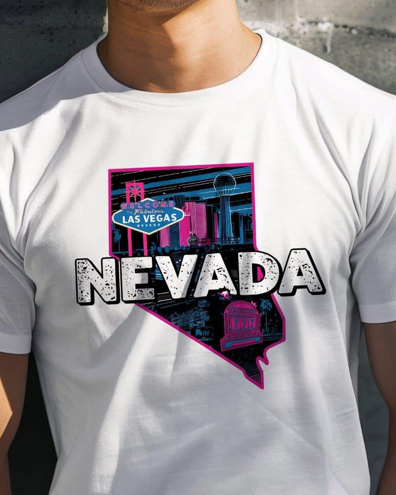 White t-shirt featuring a graphic design of the Nevada state outline filled with a stylized Las Vegas cityscape and the word NEVADA.