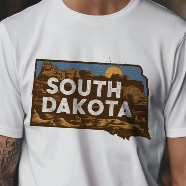 White T-Shirt Featuring A Vintage-Style Graphic Of The South Dakota State Outline, Incorporating Mount Rushmore And A Setting Sun.
