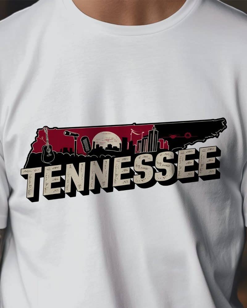 White t-shirt with a graphic of the state of Tennessee, incorporating a cityscape, musical instruments, and the word Tennessee in vintage lettering.